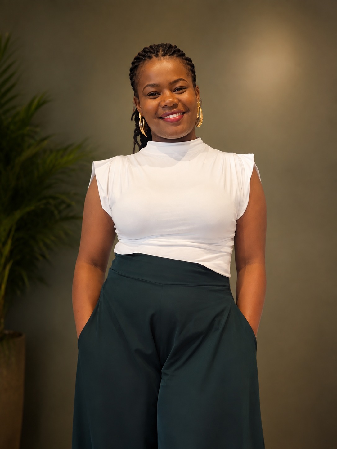 Janet Wanjiku in a calm, plant-filled space, reflecting the grounded approach of her practice